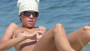 Nude brunette voyeur goes wild on cock at the beach