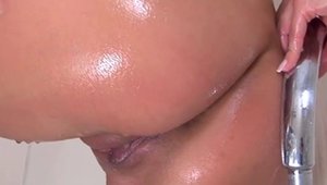 Shaved brunette masturbating in the shower